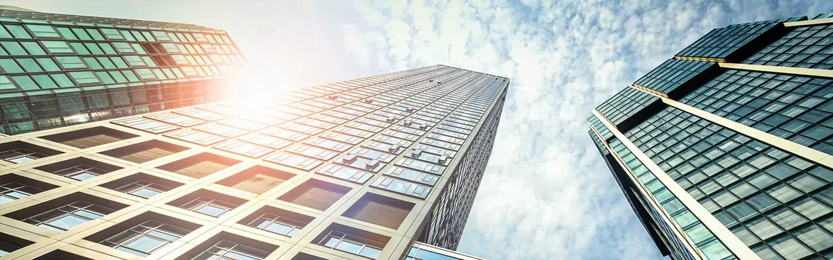 Sunlit glass office towers seen from below